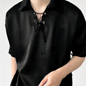 Homme portant une blouse noir en satin, fond blanc.