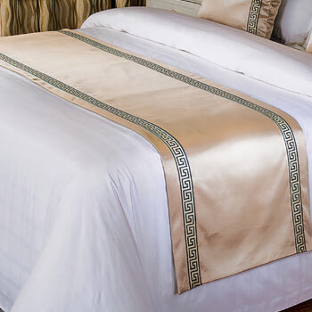 Couvre lit en satin doré sur lit blanc