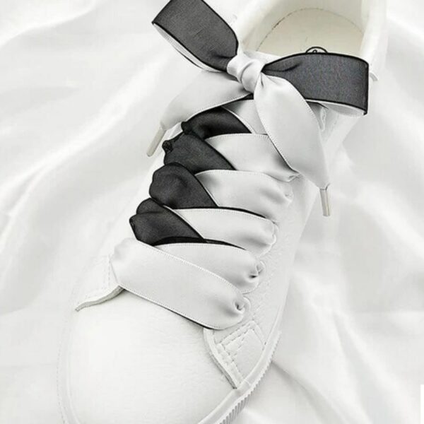 Paire de chaussures blanches avec lacets blanc et noir.