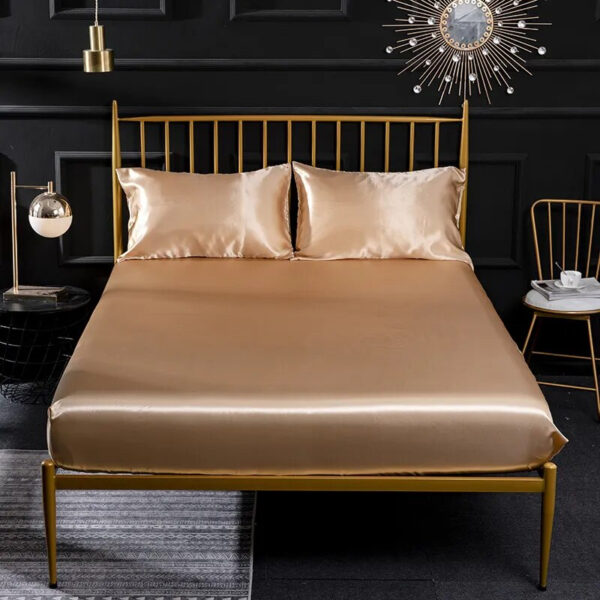 On voit une chambre à coucher d'adulte avec des murs sombres et un lit paré de draps en satin beige.