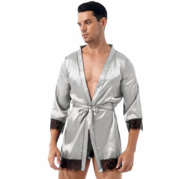 Homme portant une robe de chambre courte grise en satin avec dentelle sur les extrémité des manches et le bas de la robe de chambre sur fond blanc.