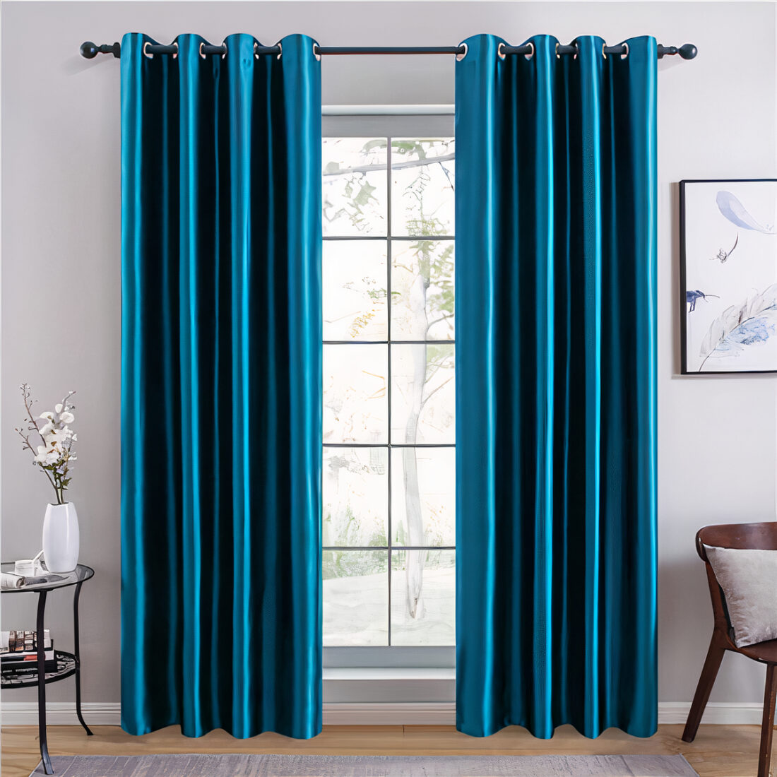 Fenêtre avec des rideaux bleus, une chaise et une table sur les côtés ainsi qu'un tableau accroché au mur