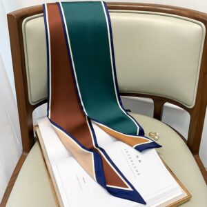 Long foulard en satin multicolore posé sur un dossier de chaise.