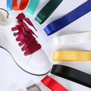 Chaussure avec lacets rouges sur fond blanc. On voit aussi des lacets de couleurs différentes autour.