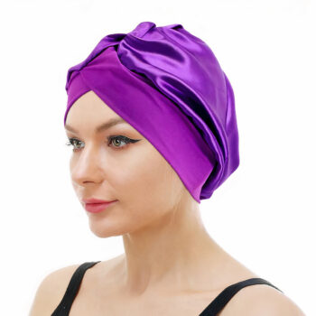 Femme portant un bonnet violet avec une bande élastique sur fond blanc.