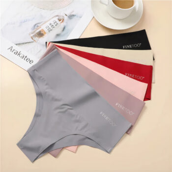 6 string de différentes couleurs, posé les un sur les autres sur un fond beige avec une tasse à café et un livre en décoration.