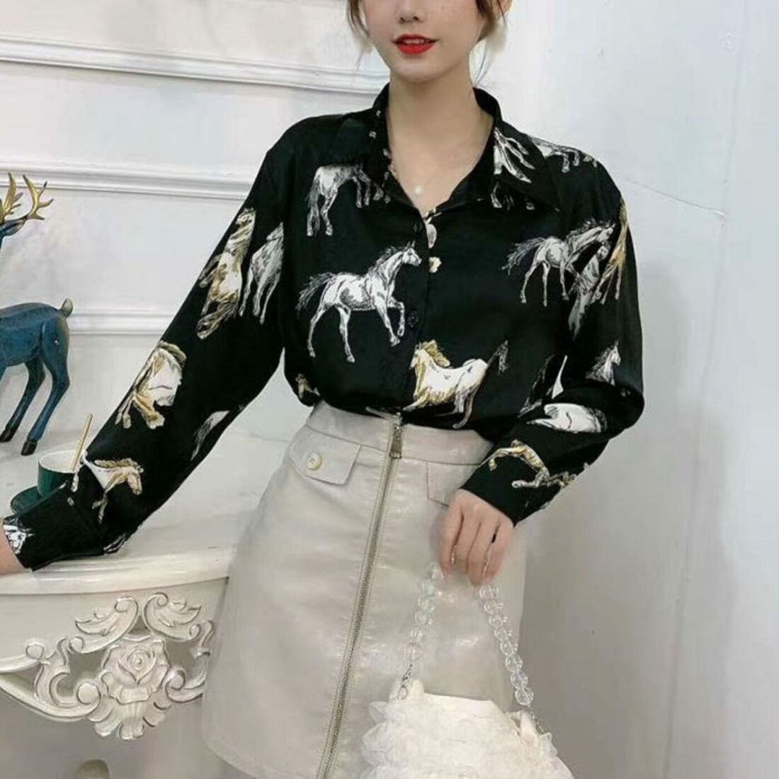 Une femme portant une chemise en satin avec un imprimé cheval sur fond noir