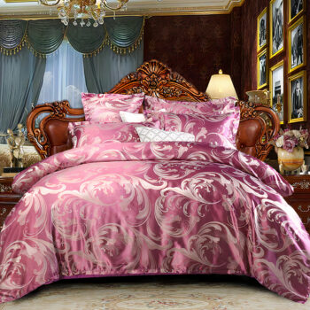 Lit rose dans une chambre à moquette blanche avec une tête de lit en bois marron et de photos encadrés sur le mur.