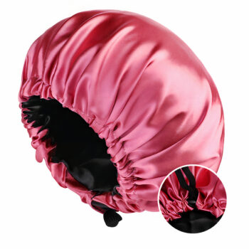 Bonnet de nuit rose en satin sur fond blanc avec lien de réglage, petite pastille ronde en bas à droite qui montre la boule de serrage.
