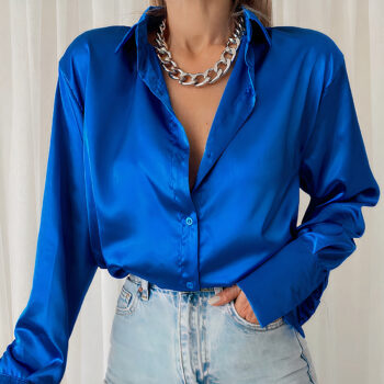Femme portant une chemise en satin bleu avec un jean et un collier de chaine