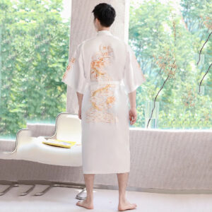 Homme de dos face à une fenêtre portant un kimono long blanc.