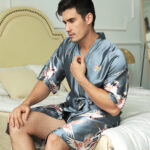 Homme portant un kimono bleu clair et assis sur un lit.