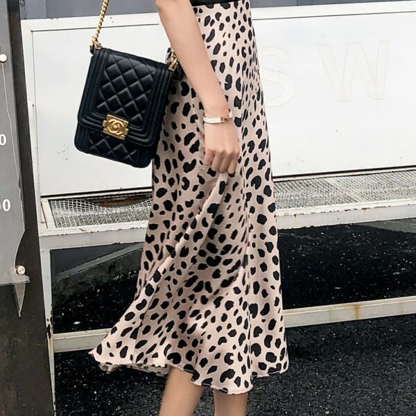 Femme portant une jupe motif léopard avec un sac à main noir