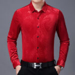 Homme portant une chemise rouge sur un fond blanc.