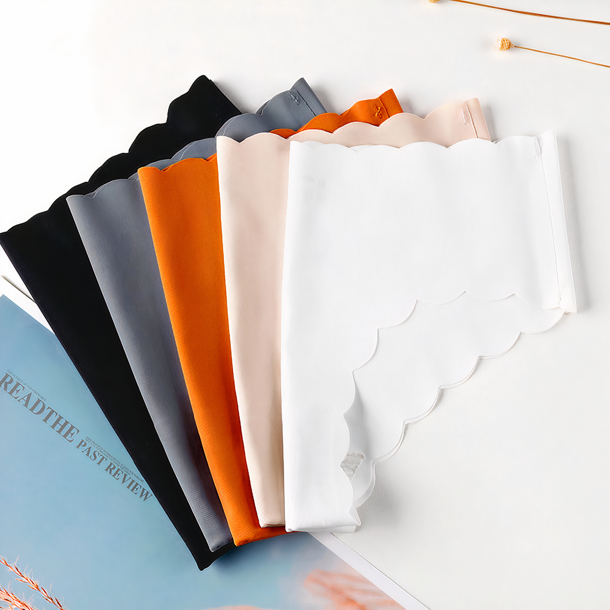 5 culottes pliées sur un fond. Une orange, une grise, une noire, une bleu et une blanche.