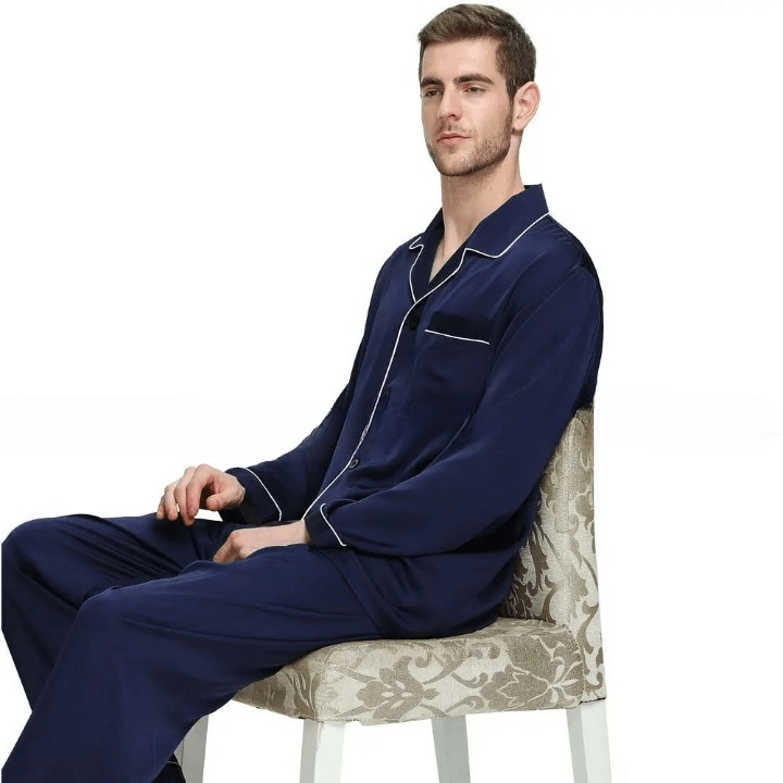 Homme assis sur un fauteuil portant un pyjama en satin bleu