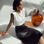 femme assise portant une jupe longue en satin noir