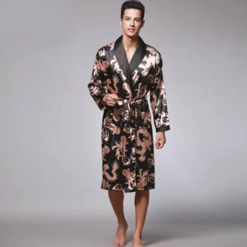 Homme portant un kimono noir en satin à motifs dorés dans un fond gris