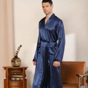 Homme portant une robe de chambre bleu foncé. On voit derrière, un fauteuil marron et une étagère.