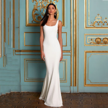 Robe de mariée minimaliste en satin blanc porté par une femme brune debout