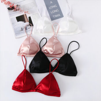 4 soutiens gorge les uns en dessous des autres : blanc, rose, noir, rouge sur un fond blanc avec un magazine en haut.