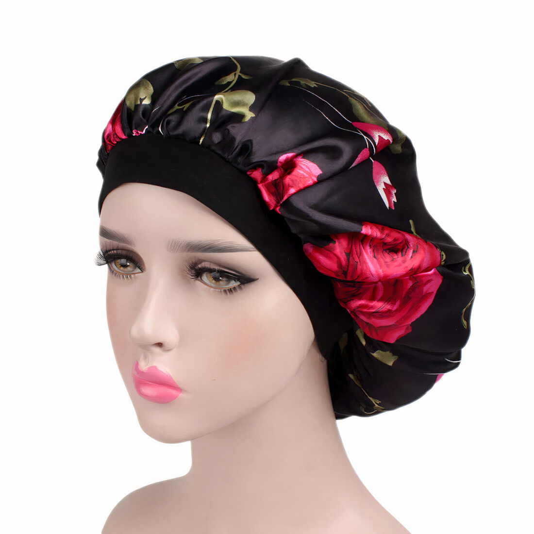 Tête à coiffer maquillée portant un bonnet en satin noir avec fleurs rouges.